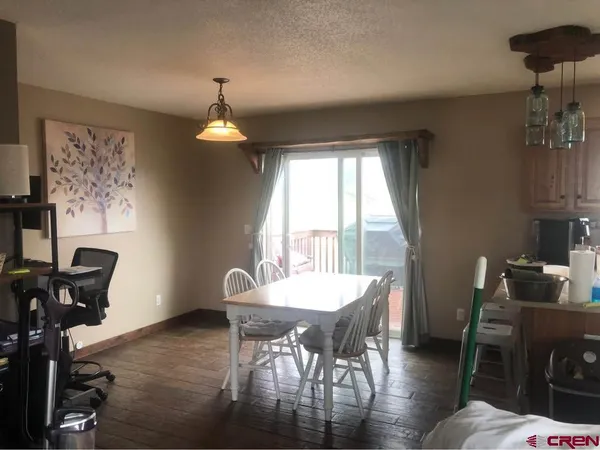 a dining room with furniture a chandelier and wooden floor