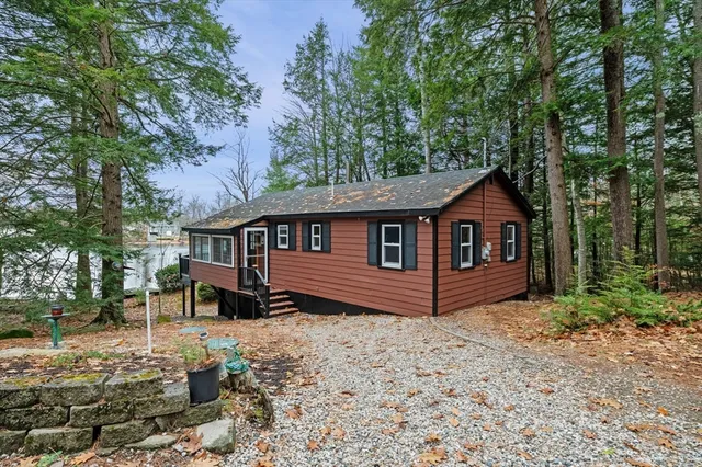 a view of a house with a yard and large tree