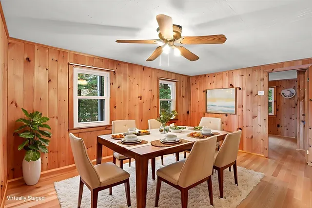 a dining room with furniture potted plants and wooden floor