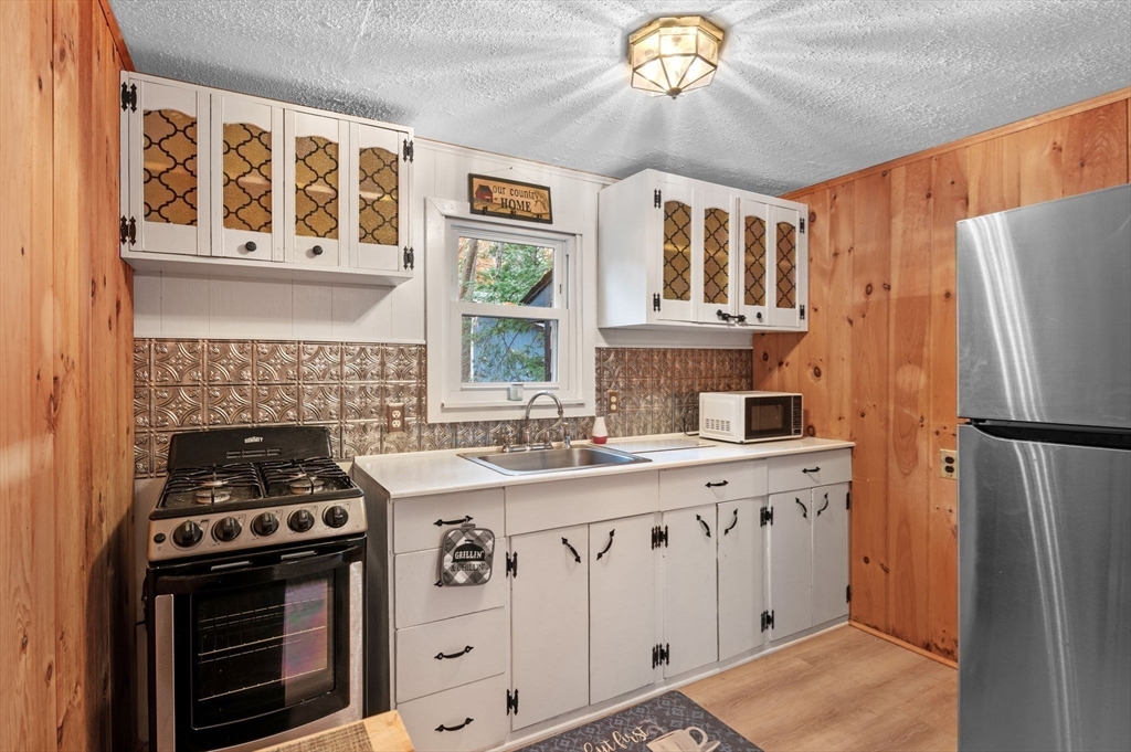 288 Pinkham Road Middleton, NH 03887 - Photo 30 of 42 a kitchen with stainless steel appliances a stove a refrigerator a sink and a cabinets
