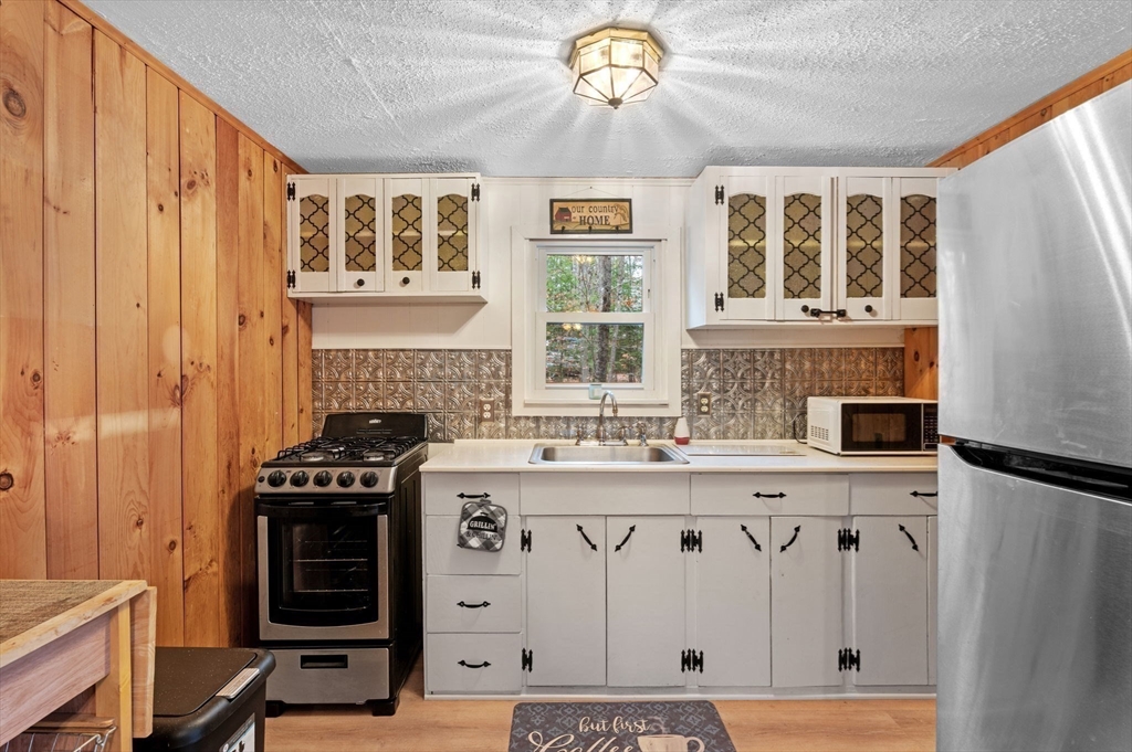 288 Pinkham Road Middleton, NH 03887 - Photo 31 of 42 a kitchen with stainless steel appliances a stove a sink and a refrigerator