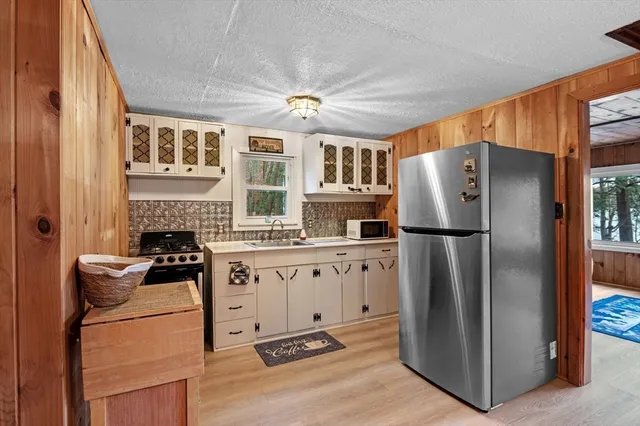 a kitchen with granite countertop a refrigerator stove and sink