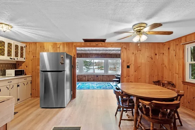 a kitchen with stainless steel appliances granite countertop a table chairs a refrigerator and a stove