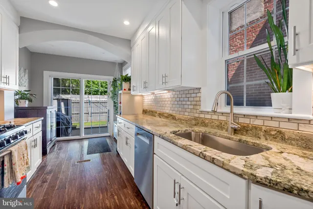 a large kitchen with stainless steel appliances granite countertop a stove sink and cabinets