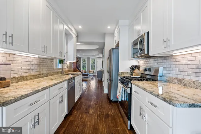 a kitchen with counter top space and wooden floor