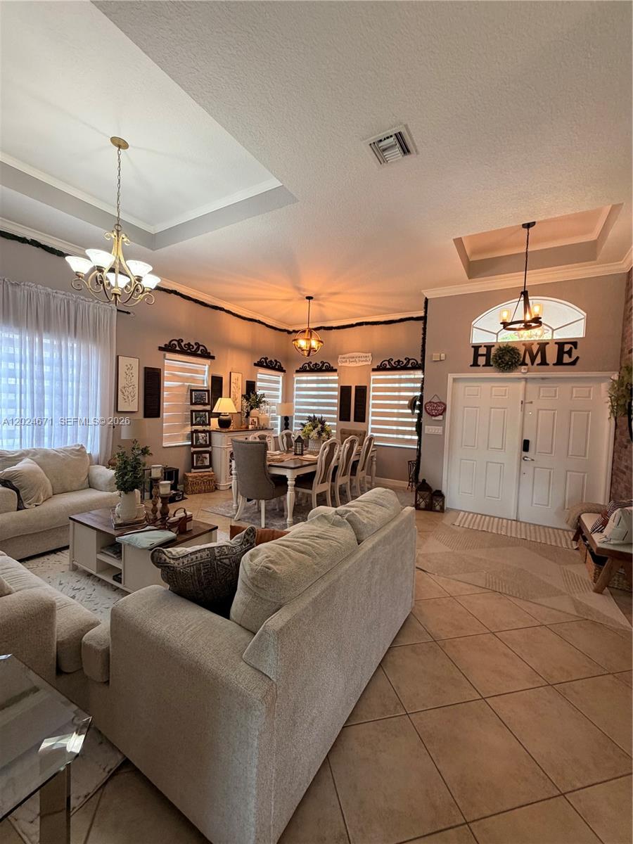 2116 Northeast 38th Road, Unit 2116 Homestead, FL 33033 - Photo 4 of 31 a living room with furniture and a chandelier