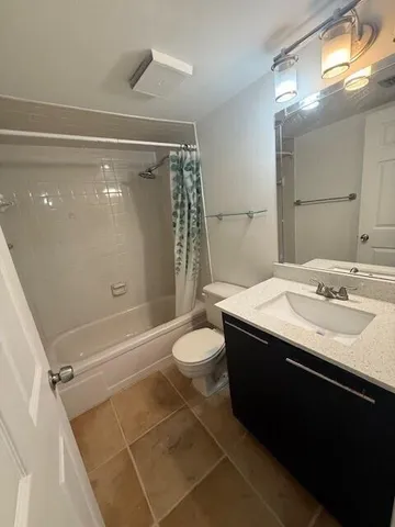 a bathroom with a granite countertop sink toilet and mirror