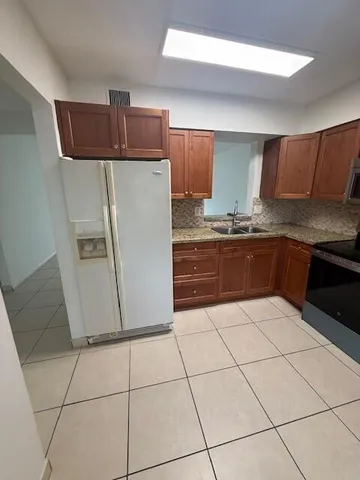 a kitchen with stainless steel appliances a sink and a refrigerator