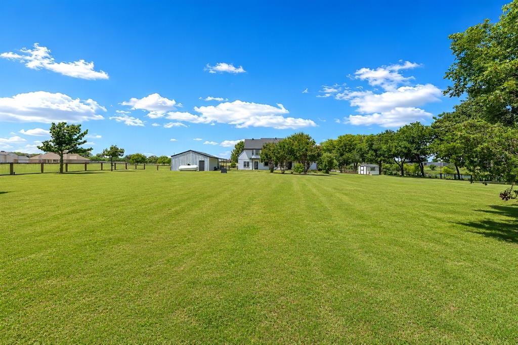 3817 Ganzer Road West Denton, TX 76207 - Photo 34 of 40 The expansive backyard opens into wide green space perfect for modern homesteading — plenty of room for a vegetable garden, fruit trees, and even a small flock of chickens. The property layout easily accommodates a full-size pool and pavilion, giving you space to create an outdoor retreat for gatherings and summer evenings. There’s also room for sand volleyball, adding a fun, active element to the yard. With mature trees and open land stretching in every direction, it’s a peaceful setting designed for both everyday living and weekend enjoyment.