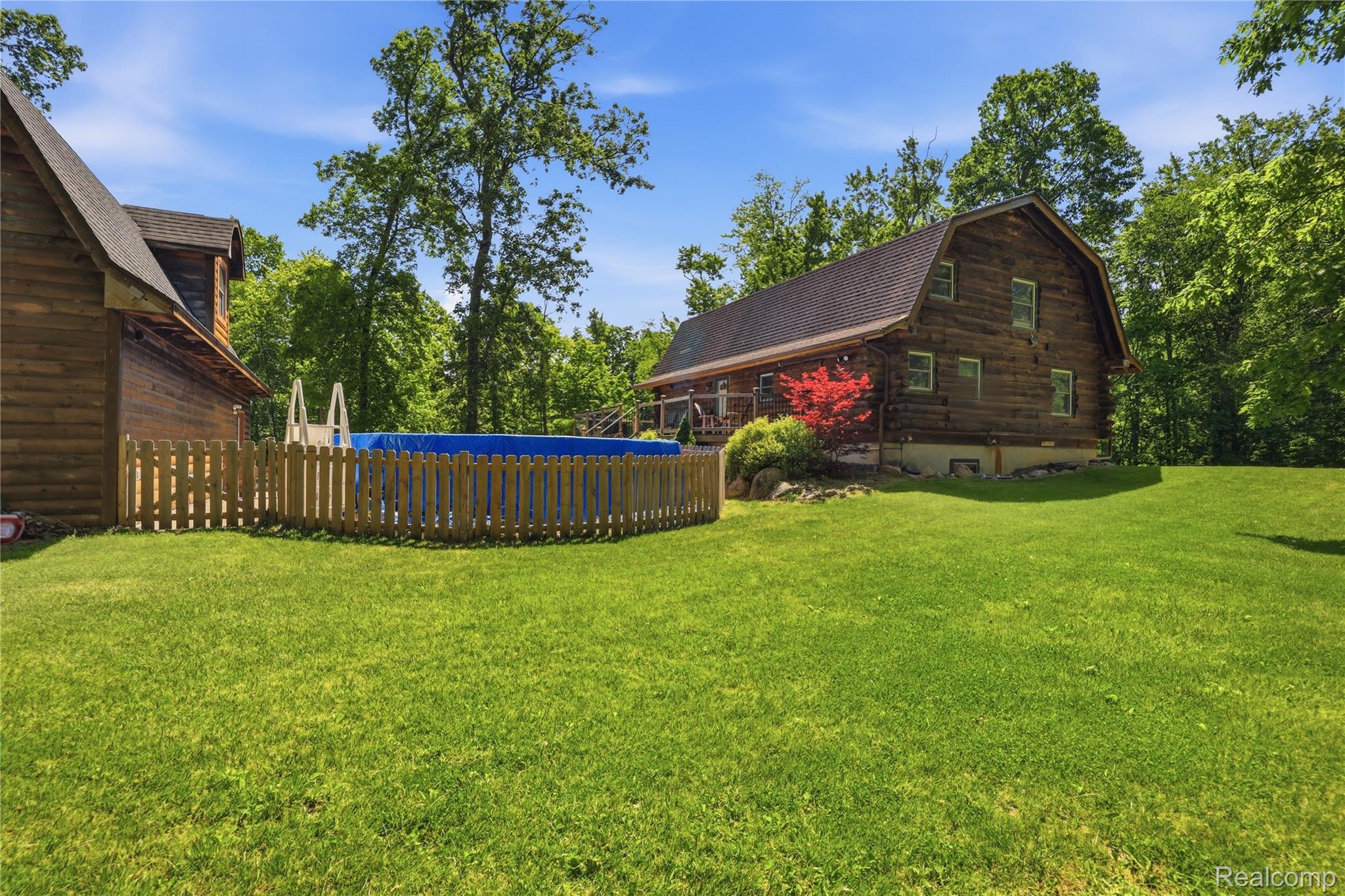 14830 Sheridan Road Byron, MI 48418 - Photo 51 of 74 Expansive lawn area with an above-ground pool enclosed by a picket fence