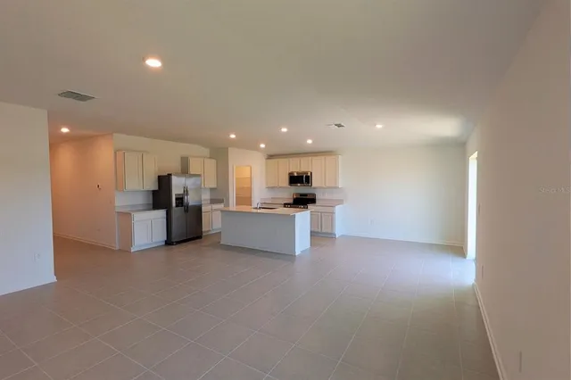 a view of kitchen with kitchen island and stainless steel appliances