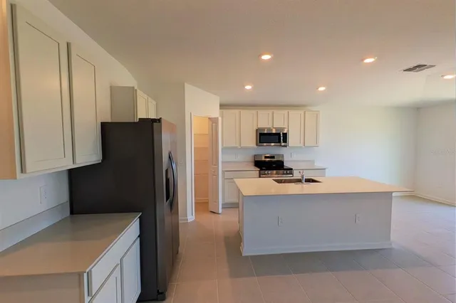 a kitchen with stainless steel appliances granite countertop a refrigerator a stove a sink and a refrigerator