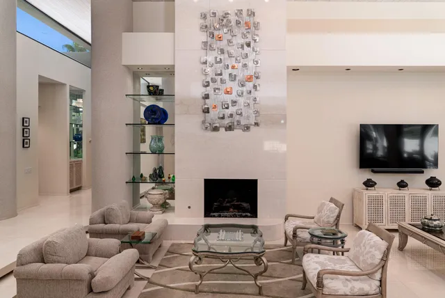 a dining room with furniture a chandelier and large windows