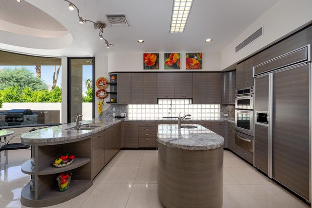a kitchen with kitchen island a large window in it