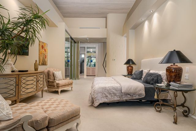 a bedroom with two beds and a glass walk in closet