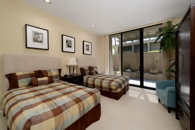 a view of a patio with a table chairs potted plants and palm trees