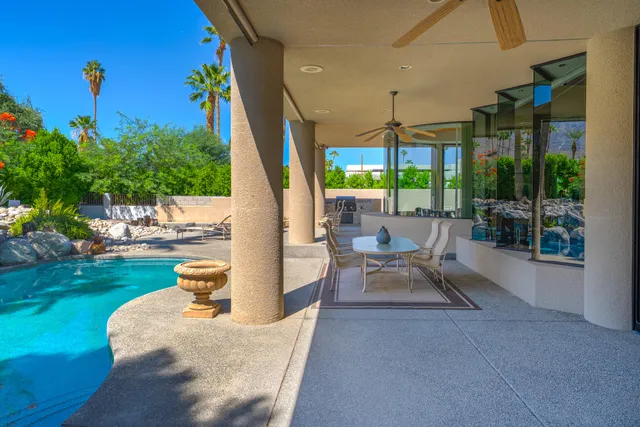 a view of a patio with table and chairs potted plants and large tree