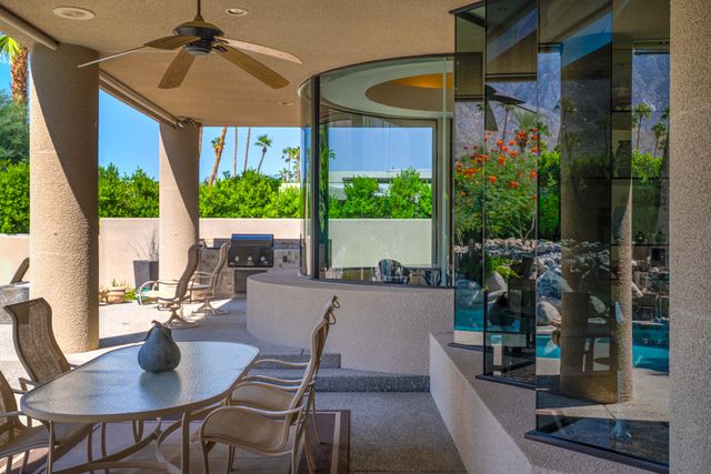 a swimming pool with outdoor seating and a potted plant