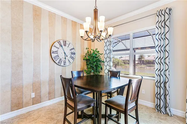 a dining room with furniture a potted plant and a chandelier