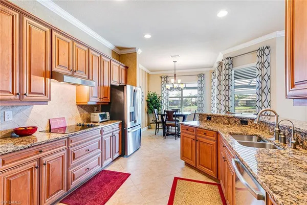 a kitchen with stainless steel appliances granite countertop sink stove top oven and cabinets