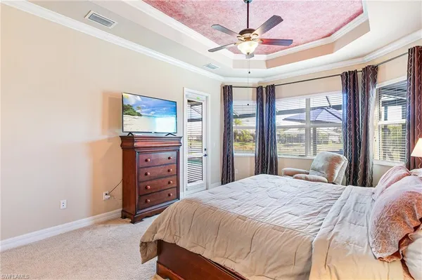 a bedroom with a bed a dresser and a large window
