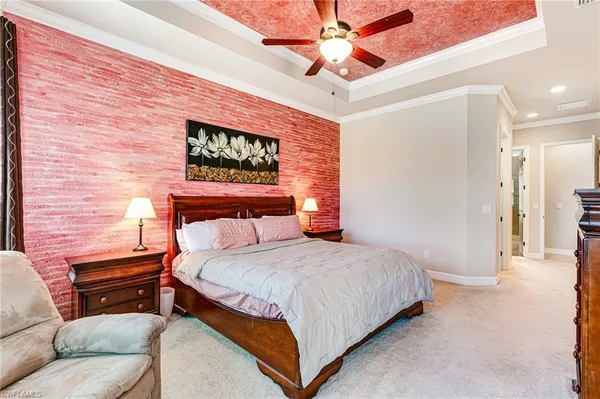 a bedroom with a bed a couch and a chandelier