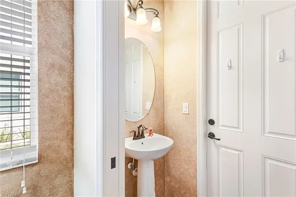 a bathroom with a sink a mirror and a window