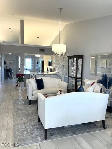 a living room with furniture and a chandelier