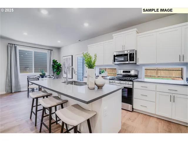 a kitchen with stainless steel appliances kitchen island granite countertop a stove a sink a microwave a dining table and chairs