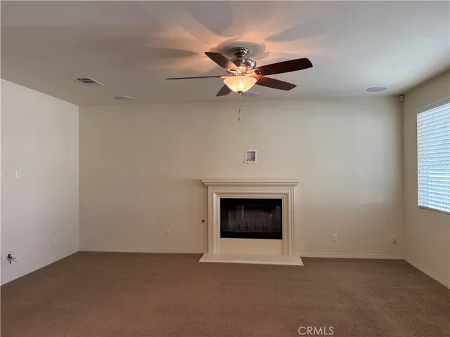 an empty room with windows and fireplace