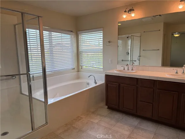 a spacious bathroom with a tub sink and mirror