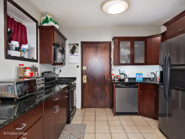 a kitchen with stainless steel appliances granite countertop a refrigerator and a stove