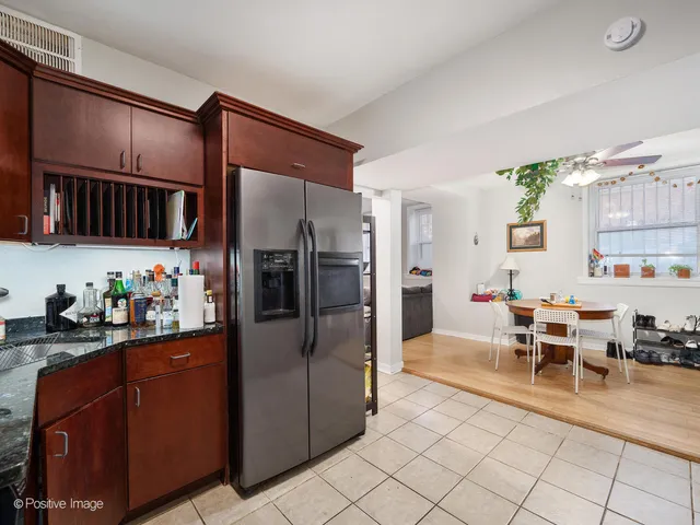 a kitchen with granite countertop stainless steel appliances a table and chairs