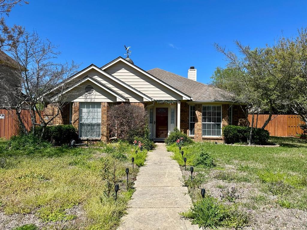 a front view of a house with a yard and potted plants