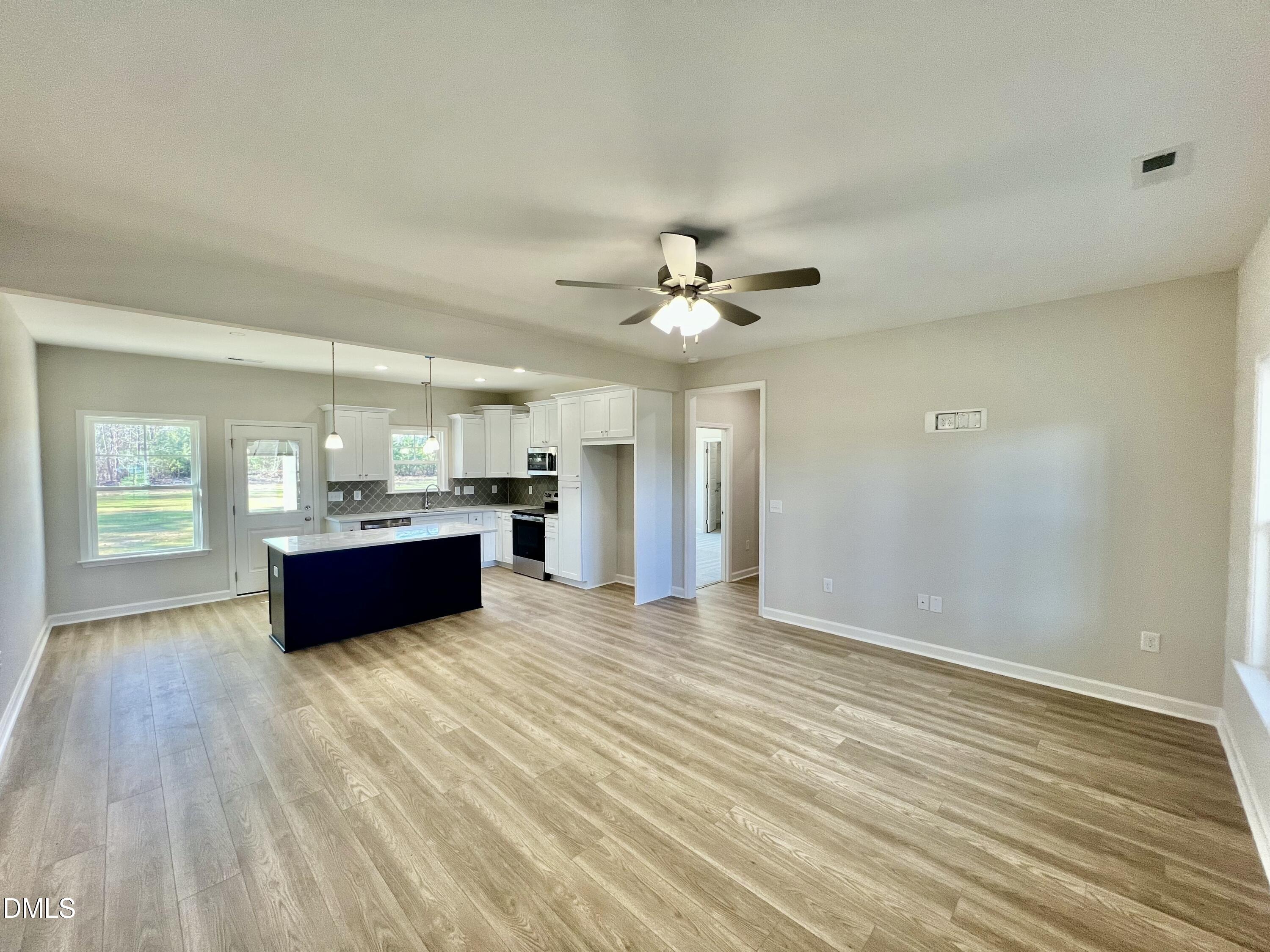 711 Polly Watson Road Fremont, NC 27830 - Photo 3 of 21 a living room with stainless steel appliances kitchen island a sink dishwasher and a fireplace with wooden floor
