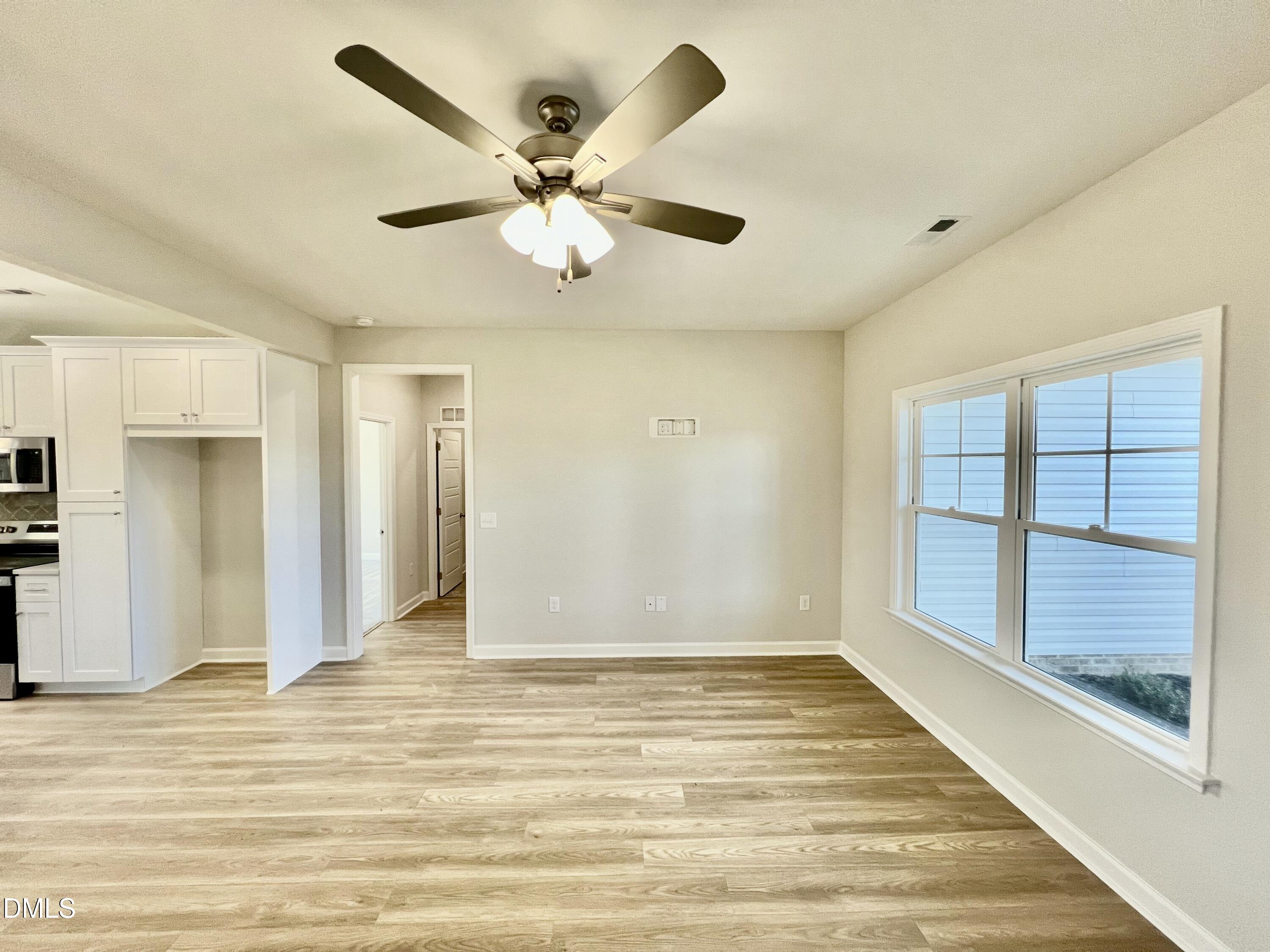 711 Polly Watson Road Fremont, NC 27830 - Photo 4 of 21 an empty room with wooden floor fan and windows