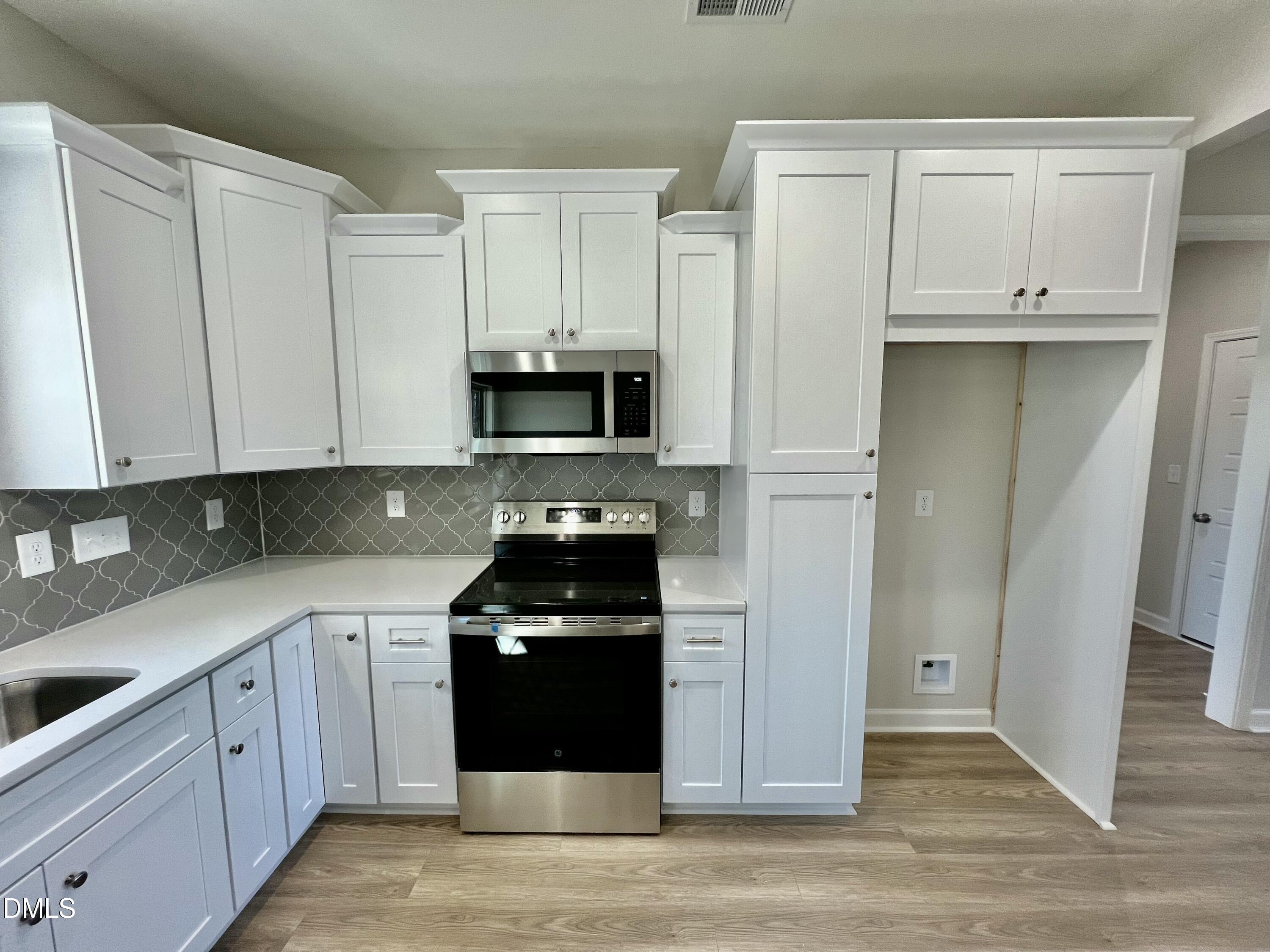 711 Polly Watson Road Fremont, NC 27830 - Photo 6 of 21 a kitchen with white cabinets and black appliances