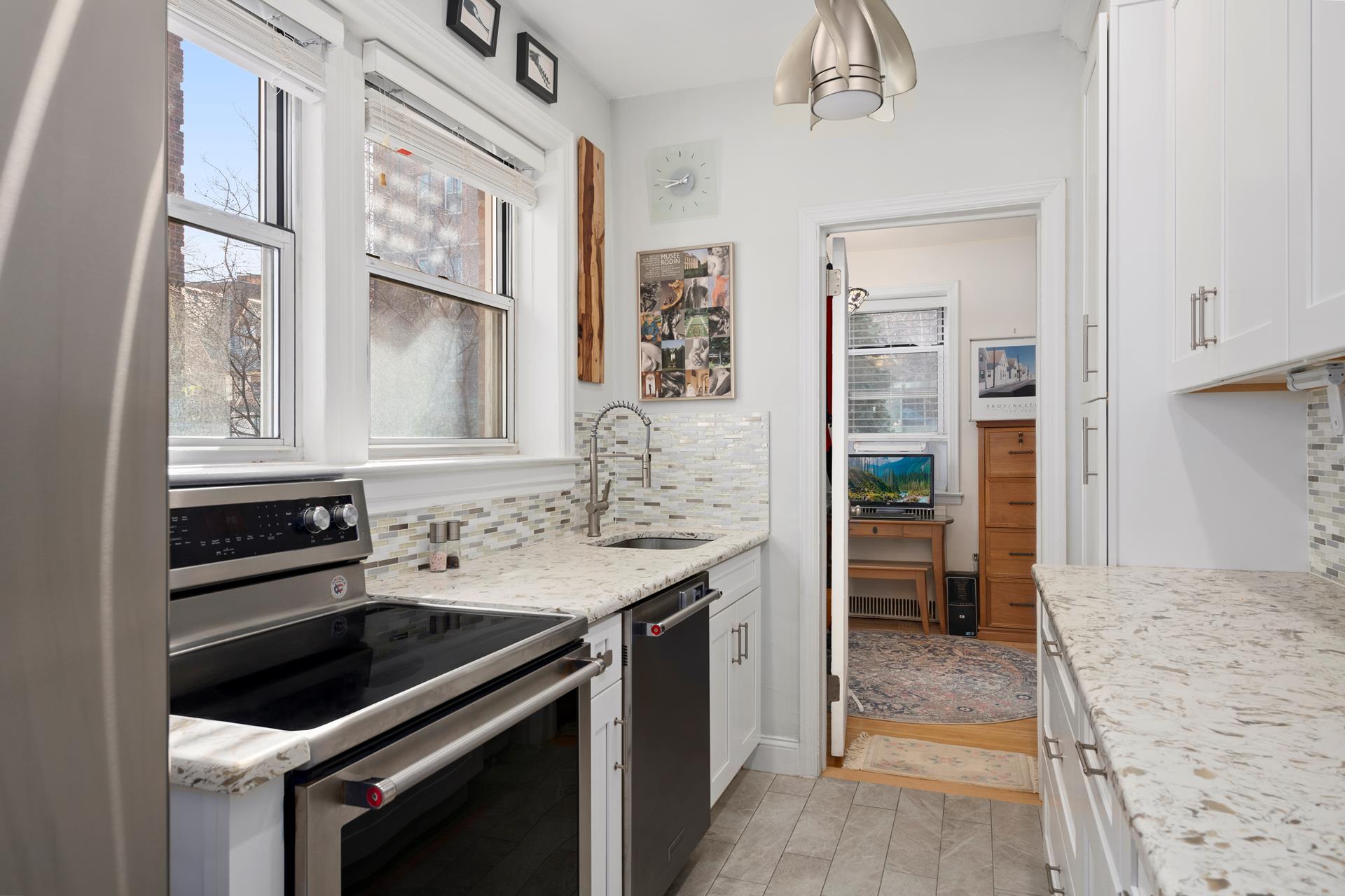 86-10 34th Avenue, Unit 113 Queens, NY 11372 - Photo 6 of 13 a kitchen with a stove and a sink