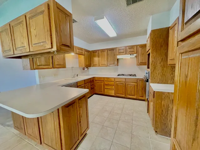 a kitchen with stainless steel appliances granite countertop a stove refrigerator and a sink