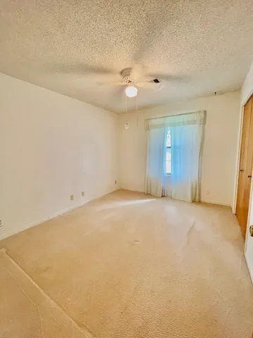 a view of a livingroom with furniture and chandelier fan