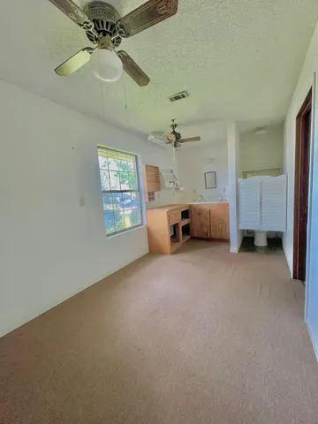 a view of a house next to a big yard and large trees