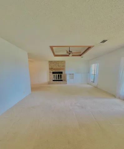a view of a room with a ceiling fan and window