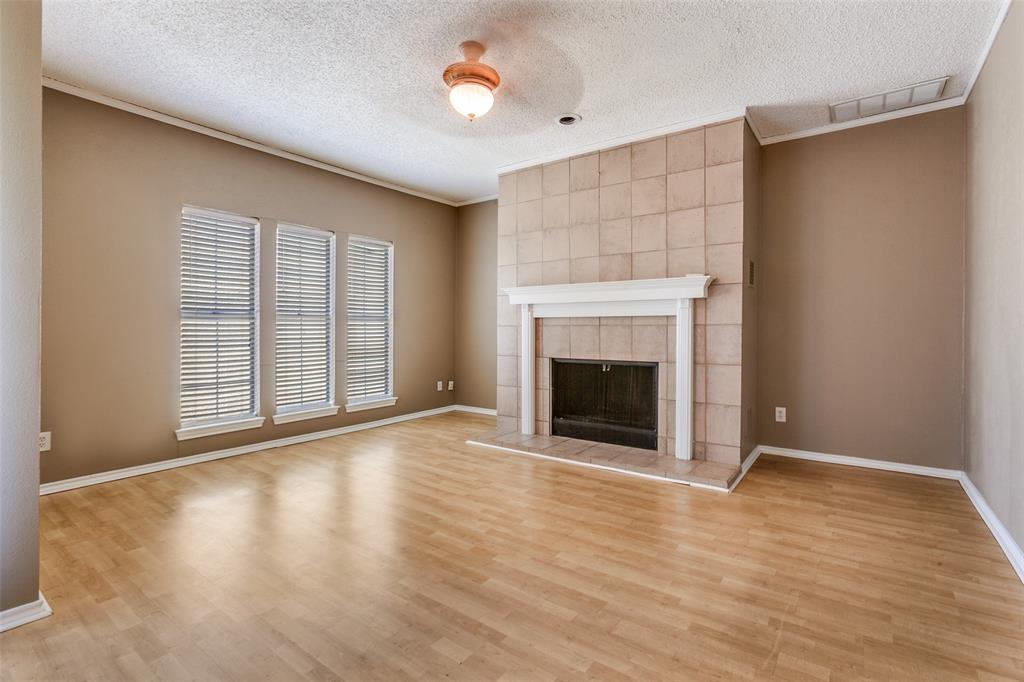 5310 Keller Springs Road, Unit 138 Dallas, TX 75248 - Photo 2 of 12 an empty room with wooden floor a fireplace and windows