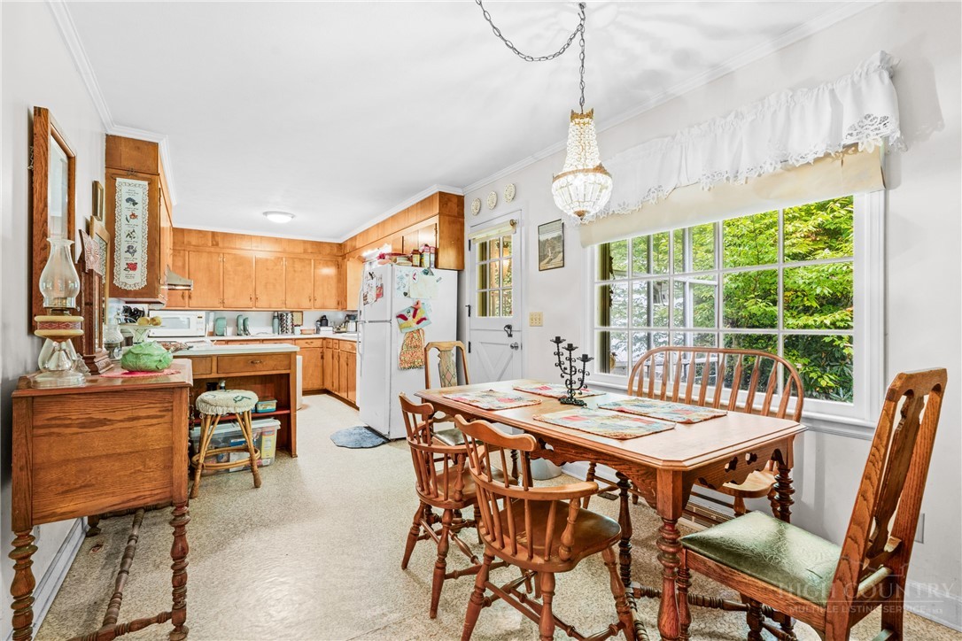 1794 Highway 105 Boone, NC 28607 - Photo 21 of 29 a dining room with furniture a chandelier and wooden floor