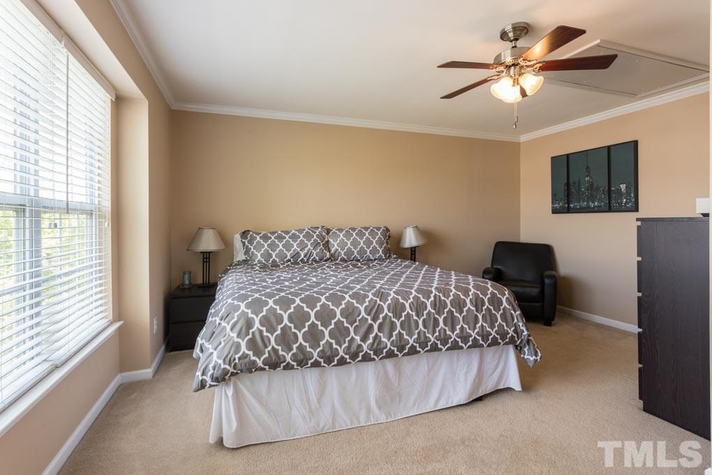 9712 Jordy Drive, Unit 291 Raleigh, NC 27617 - Photo 11 of 15 a bedroom with a bed and a chandelier