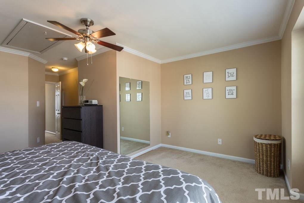 9712 Jordy Drive, Unit 291 Raleigh, NC 27617 - Photo 12 of 15 a bedroom with a bed and a chandelier