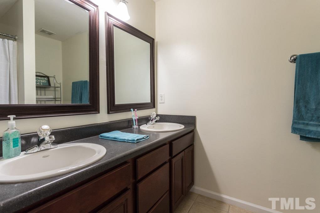 9712 Jordy Drive, Unit 291 Raleigh, NC 27617 - Photo 13 of 15 a bathroom with a double vanity sink and a mirror