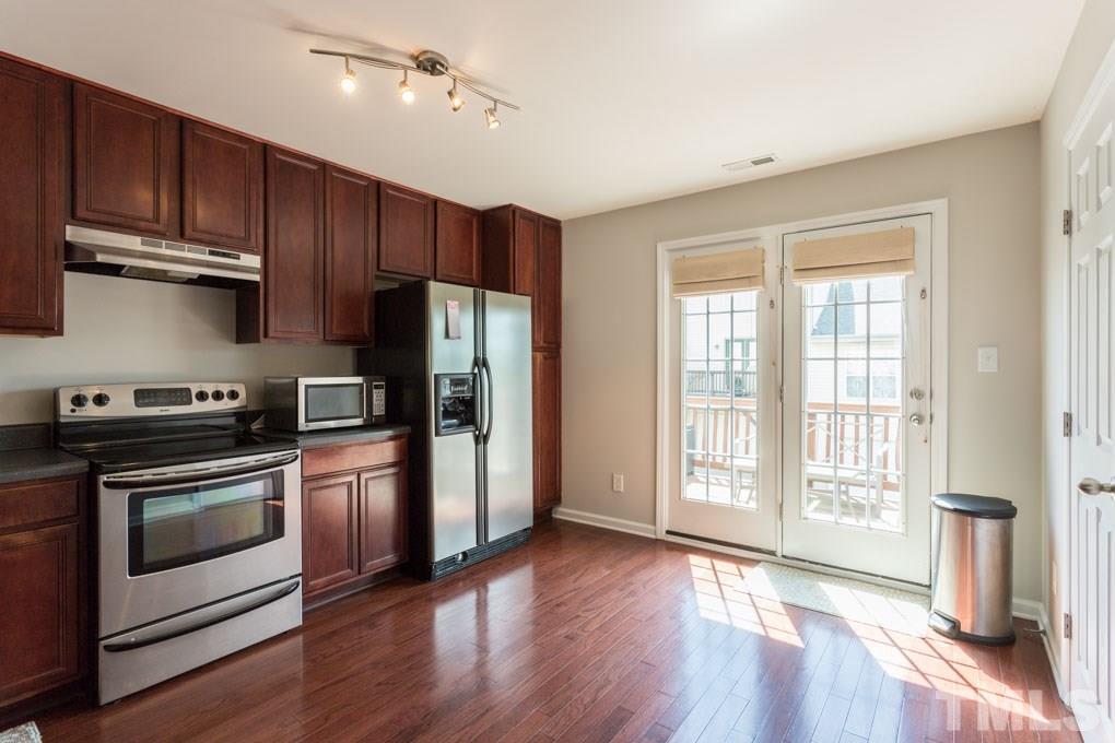 9712 Jordy Drive, Unit 291 Raleigh, NC 27617 - Photo 6 of 15 a kitchen with stainless steel appliances granite countertop a refrigerator a stove a sink and dishwasher with wooden floor