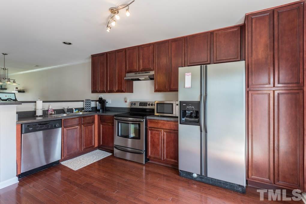 9712 Jordy Drive, Unit 291 Raleigh, NC 27617 - Photo 7 of 15 a kitchen with granite countertop wooden cabinets and stainless steel appliances