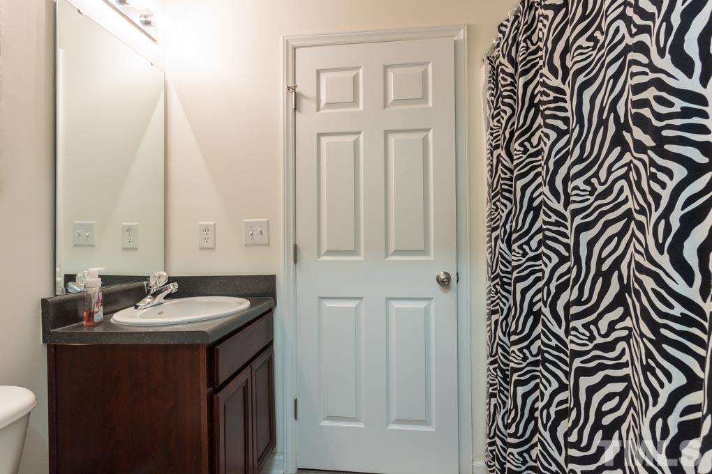 9712 Jordy Drive, Unit 291 Raleigh, NC 27617 - Photo 8 of 15 a bathroom with a sink a mirror and a shower